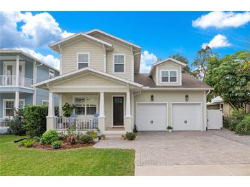 Two-story house with a two car garage, front porch, and landscaped yard at 1018 Wilks Ave, Belle Isle, FL 32809
