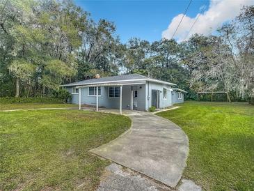Ranch home with carport, curved driveway & grassy yard at 143 N Woodward Ave, Deland, FL 32720