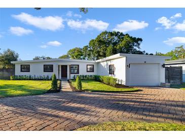 Updated home exterior boasts a modern design, paved driveway, and manicured lawn at 5201 Lake Howell Rd, Winter Park, FL 32792