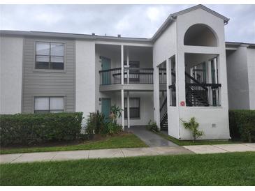 Well-maintained condo building with landscaping and a walkway at 2260 Cascades Blvd # 107, Kissimmee, FL 34741