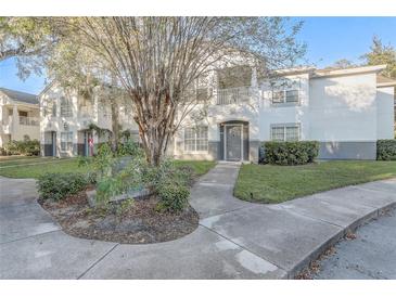 Two story townhome with gray siding, landscaping, and walkway at 4352 S Kirkman Rd # 1213, Orlando, FL 32811