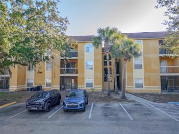 Two-story condo building with palm trees and parking at 5259 Images Cir # 108, Kissimmee, FL 34746