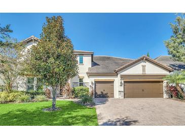Two-story house with a two-car garage and landscaped lawn at 8441 Chilton Dr, Orlando, FL 32836