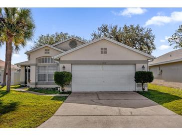 Front view of a single-story house with a two-car garage and landscaping at 2238 Wyndam Way, Kissimmee, FL 34743
