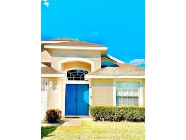 House exterior featuring a two-car garage and blue front door at 2707 Prestwick Ln, Kissimmee, FL 34744