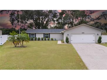 Updated single-story home with a white garage door and well-manicured lawn at 4851 Foxrun Cir, Lakeland, FL 33813