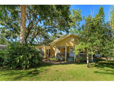 Charming yellow bungalow home with lush landscaping and a spacious front yard at 133 Agnes St, Winter Garden, FL 34787