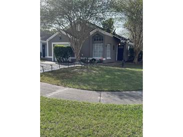 Gray house with a white garage door and landscaping at 378 Southern Charm Dr, Orlando, FL 32807