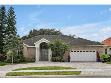 Brick house with a 3-car garage and paved driveway at 349 Plantation Club Dr, Debary, FL 32713