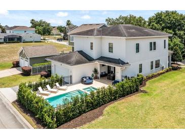 Two-story home with pool and detached garage; lush landscaping at 7423 Sparkling Ct, Reunion, FL 34747