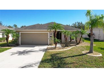 Tan, single-story home with attached two-car garage and landscaped yard at 149 Springberry Ct, Daytona Beach, FL 32124