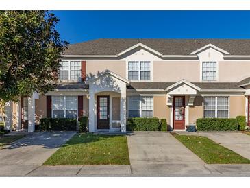 Tan two-story townhome with dark brown doors and landscaping at 2361 Silver Palm Dr, Kissimmee, FL 34747