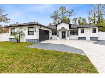 Modern house exterior with dark gray roof, white walls, and a stone accent at 14324 Roxane Dr, Orlando, FL 32832