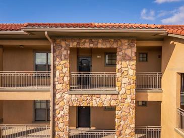 Exterior view of a condo building with stone accents and balconies at 903 Charo Pkwy # 836, Davenport, FL 33897