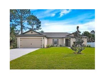 Single-story home with attached garage and landscaped lawn at 1217 Gladstone Dr, Deltona, FL 32725