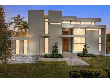 Modern home with sleek design, light color, and a landscaped lawn at 2661 Via Tuscany, Winter Park, FL 32789