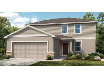 Two-story house with light beige vinyl siding, a brown door, and a two-car garage at 622 Teviot Rd, Haines City, FL 33844