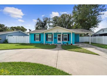 Cute teal home with a circular driveway and nicely landscaped lawn at 1090 Henry Balch Dr, Orlando, FL 32810