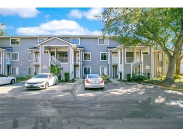 Two-story building exterior with gray siding, parking, and landscaping at 2223 Stonington Ave # 2223, Orlando, FL 32817