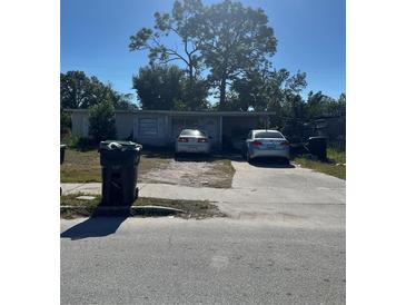 Ranch-style home with driveway and mature trees at 5022 Keith Pl, Orlando, FL 32808