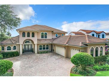 Two-story house with tile roof, three-car garage, and a brick paved driveway at 6245 Little Lake Sawyer Dr, Windermere, FL 34786