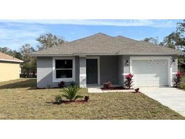 Newly constructed home with gray siding, attached garage, and landscaping at 6929 Central Ave, Mulberry, FL 33860