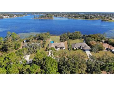 Aerial view of waterfront home with private pool and expansive lake views at 2032 Dumas Dr, Deltona, FL 32738