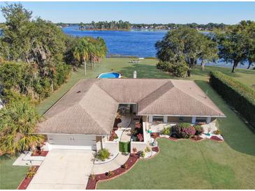 Single-story home with lakefront access, private pool, and mature landscaping at 2032 Dumas Dr, Deltona, FL 32738