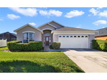 One-story house with a two-car garage, and manicured lawn at 2522 Oneida Loop, Kissimmee, FL 34747