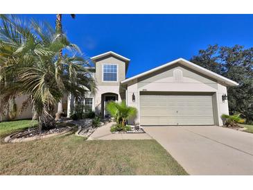 Two-story house with a two-car garage, landscaping, and palm trees at 3890 Kruger Rand Cv, Sanford, FL 32771