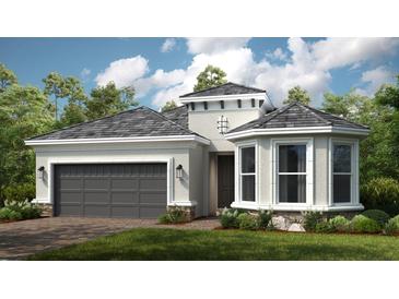 Single-story home with gray roof, attached garage, and landscaping at 857 Arbor Green Trl, St Cloud, FL 34771