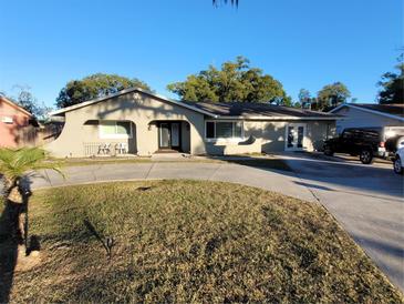 Single story home with circular driveway, landscaped lawn, and attached garage at 910 Rangeline Rd, Longwood, FL 32750