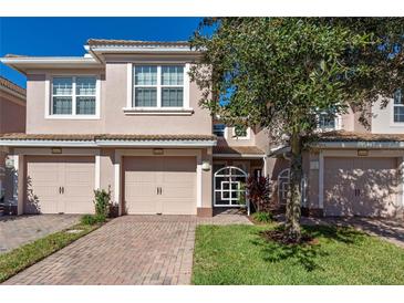 Two-story townhome with two-car garage and landscaped front yard at 8345 Bella Tierra Ct # 8345, Davenport, FL 33896