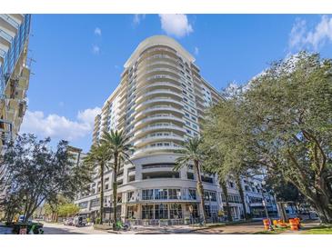 Modern high-rise building with palm trees and city views at 100 S Eola Dr # 1411, Orlando, FL 32801