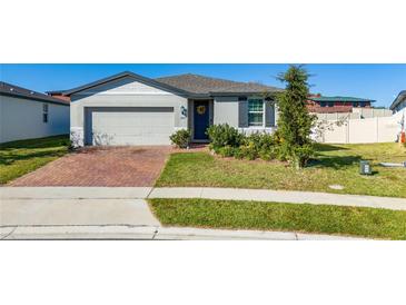 Single-story house with brick driveway, landscaped yard, and attached garage at 1251 Citrus Landing Blvd, Davenport, FL 33837