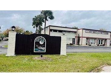 Gated community entrance of The Village, featuring a building with parking at 3928 Crayrich Cir # A12, Orlando, FL 32839