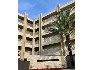 Tan three-story building with balconies and palm trees at 4501 S Atlantic Ave # 4090, New Smyrna Beach, FL 32169