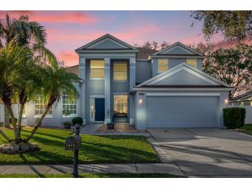 Two-story house with gray siding, a three-car garage, and a manicured lawn at 1813 Sugar Cove Ct, Ocoee, FL 34761