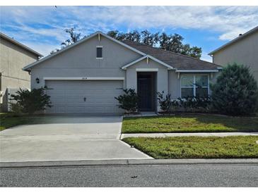 One-story house with attached garage, landscaping, and driveway at 1884 Hickory Bluff Rd, Kissimmee, FL 34744