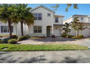 Two-story house with a white exterior, two palm trees, and a brick driveway at 4738 Sleepy Hollow Dr, Kissimmee, FL 34746
