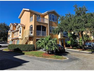 Two-story condo building with multiple units, parking, and landscaping at 12020 Villanova Dr # 101, Orlando, FL 32837