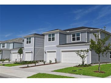 Two-story townhouses with attached garages and landscaping at 3145 Emerald Acres Ln, Sanford, FL 32771