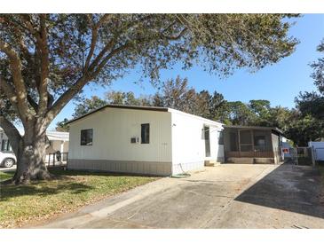 Single-wide mobile home with carport and mature tree in front at 165 Moss Dr, Debary, FL 32713