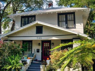 Charming two-story home with a red front door and well-manicured landscaping at 705 E Pine St, Orlando, FL 32801