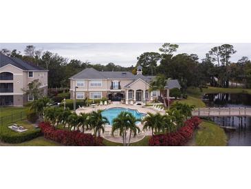 Community pool with lounge chairs, bridge, and lush landscaping at 940 Village Trl # 9-303, Port Orange, FL 32127