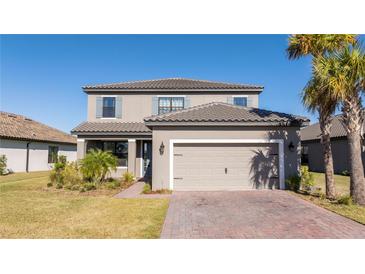 Two-story home with gray siding, tile roof, and a two-car garage at 1541 Goblet Cove St, Kissimmee, FL 34746
