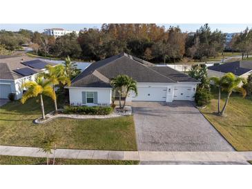 Aerial view of a single-Gathering home with a paved driveway and landscaped yard at 402 Blue Lake Cir, Kissimmee, FL 34758