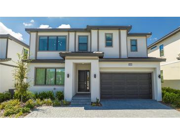 Two-story house with gray and white exterior, dark garage door, and landscaped yard at 6240 Sand Skipper Rd, Orlando, FL 32821