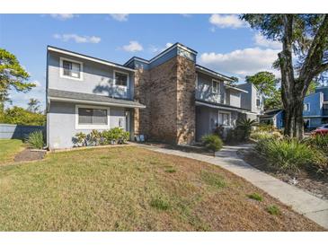 Attractive townhome with gray siding and brick accents, showcasing a well-maintained lawn at 707 Saint Matthew Cir, Altamonte Springs, FL 32714