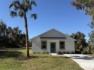 Newly constructed home with a white exterior, teal door, and palm tree at 991 S Delaware Ave, Deland, FL 32720